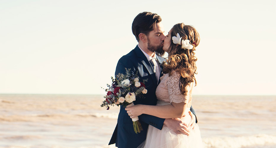 bride and groom kissing on the beach - englewood and venice area wedding hair and makeup